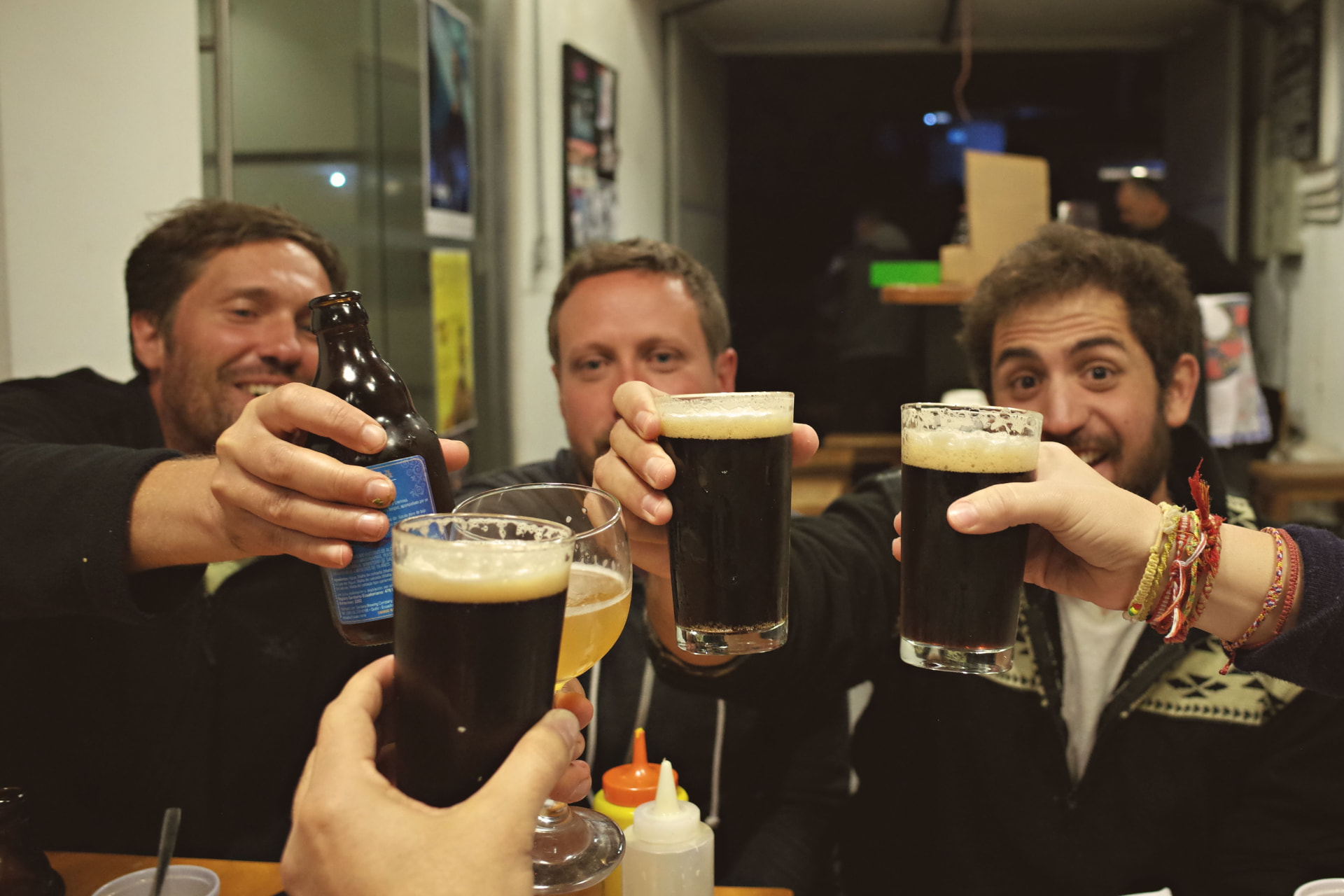 Group of mates toasting with dark beers