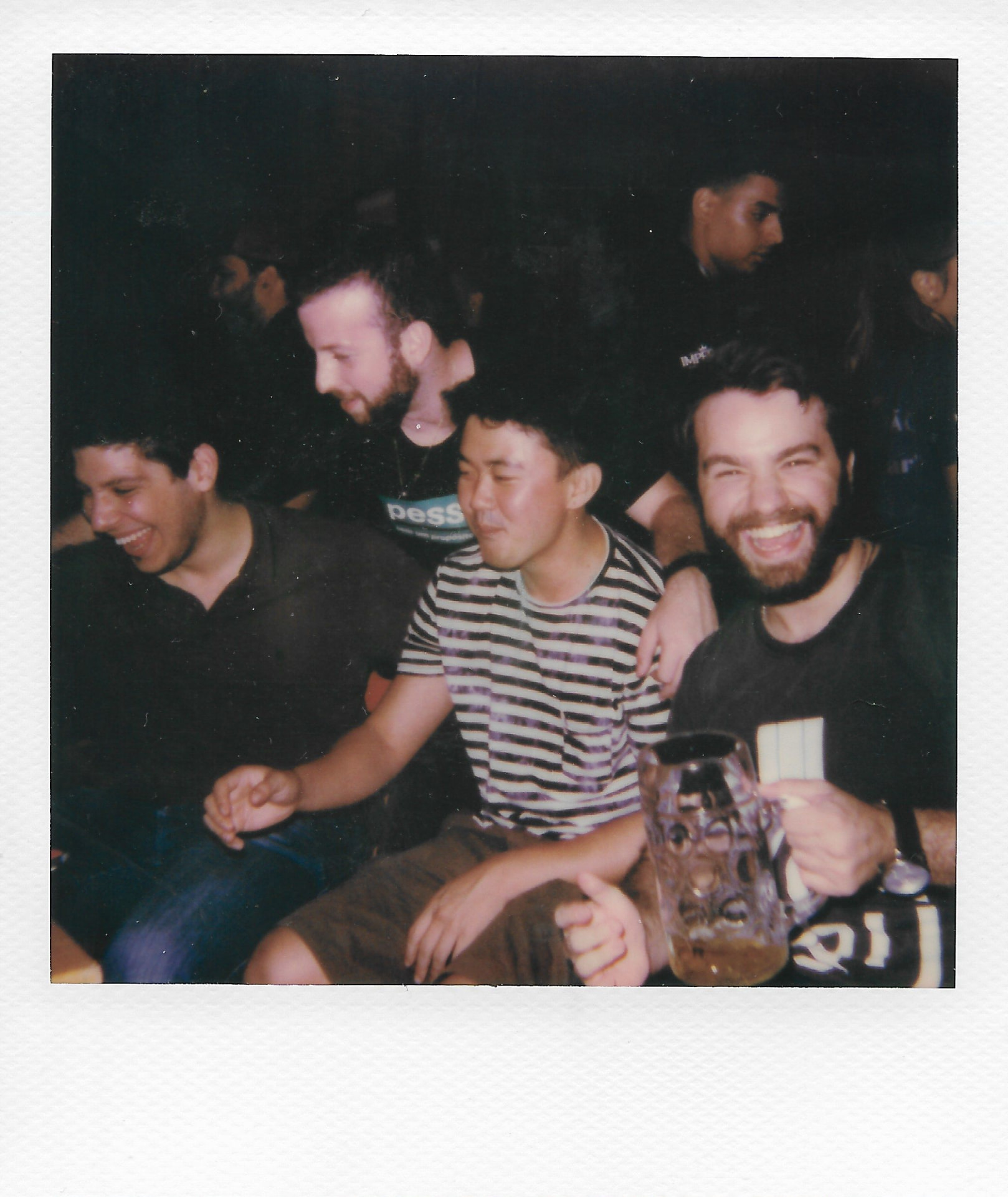 A group of mates laughing together over beers at a pub