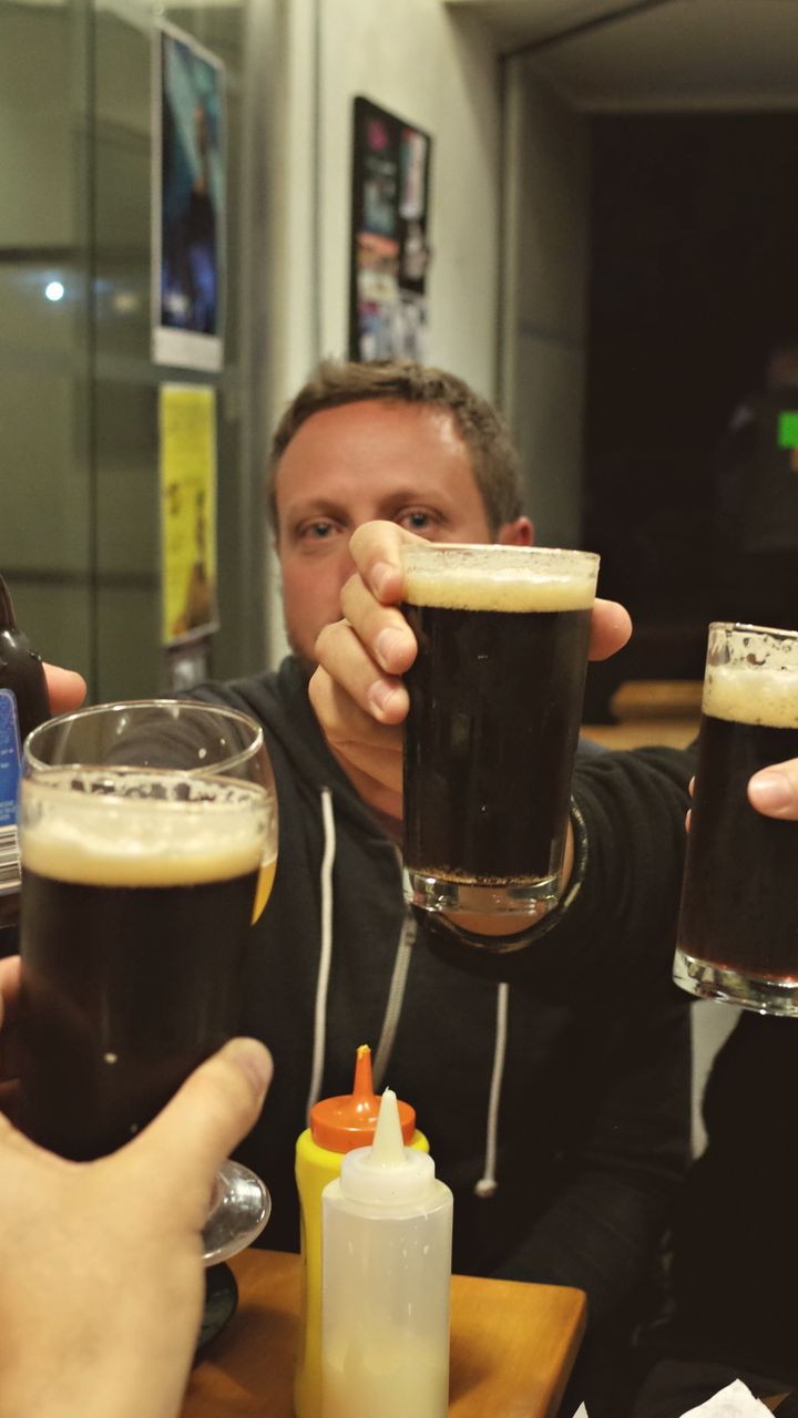 Group of mates toasting with dark beers